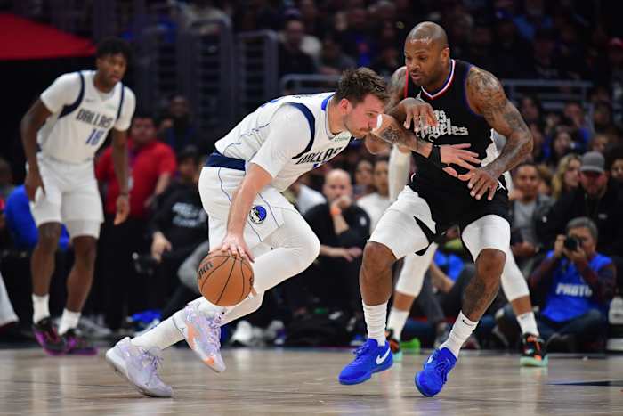 Dallas Mavericks guard Luka Doncic (77) moves the ball against Los Angeles Clippers forward P.J. Tucker (17) during the first half at Crypto.com Arena in Los Angeles, California, on Nov. 25, 2023.